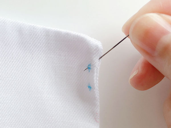 縫い目の間から針を入れて玉結びを隠します