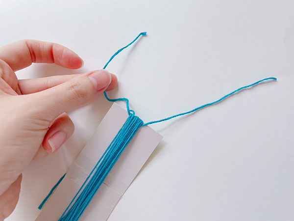 20cmくらいにカットした刺繍糸を、厚紙との間に通します。